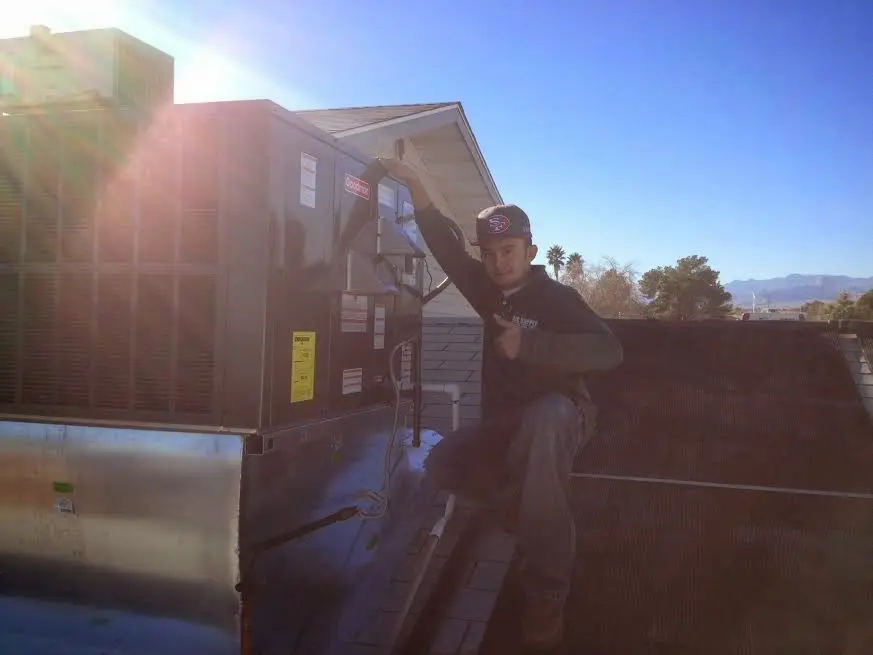 HVAC technician performing AC Tune-Up on a rooftop unit in Camp Swift